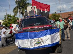 Simpatizantes exhiben una fotografía del presidente nicaragüense, Daniel Ortega, durante una marcha del oficialista Frente Sandinista de Liberación Nacional. EFE/J. Torres