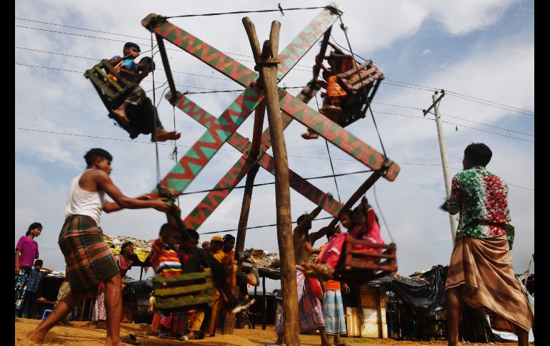 Refugiados rohinyás disfrutan de un paseo en una rueda de la fortuna de madera, en el marco de la celebración musulmana de la 