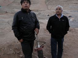 Dos de los mineros muestran la entrada sellada de la sonda por donde recibían alimentos, ropa y accesorios durante los 70 días que permanecieron atrapados. EFE/ARCHIVO