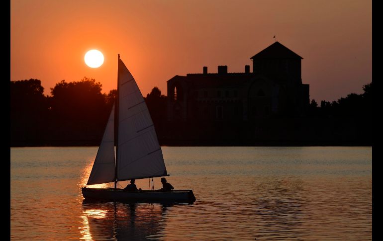 Un bote navega por el lago Old durante el atardecer en Tata, Hungría. EFE/Z. Czegledi