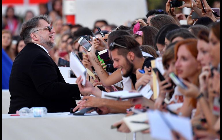 El director mexicano firma autógrafos.