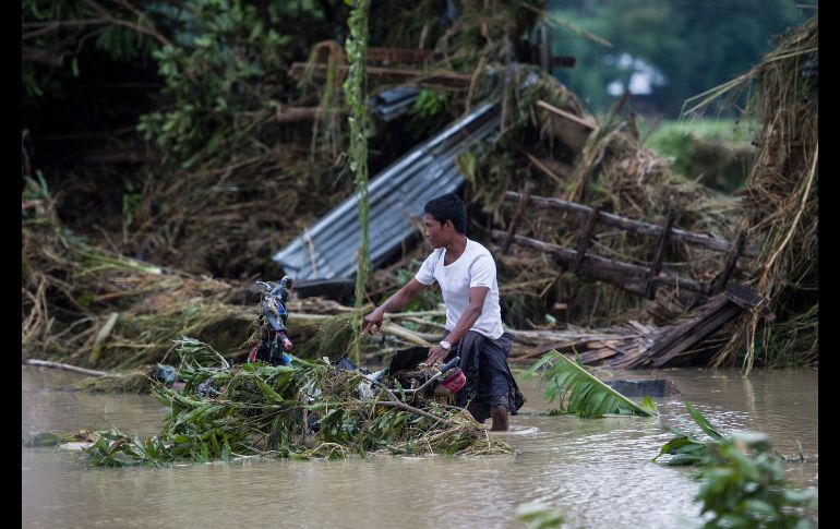 Un habitante camina en Swar, Birmania, una población inundada por aguas de la presa, que registró una ruptura por las fuertes lluvias de la temporada. AFP/Y. Aung