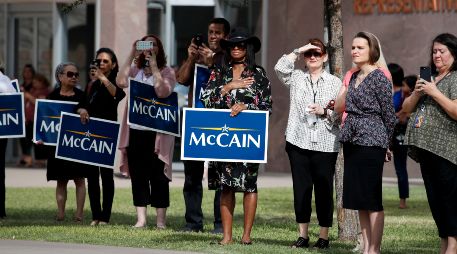 Habitantes de Arizona salen al paso de la caravana que transporta los restos del senador John McCain partiera del Capitolio estatal. AP / J. C. Hong