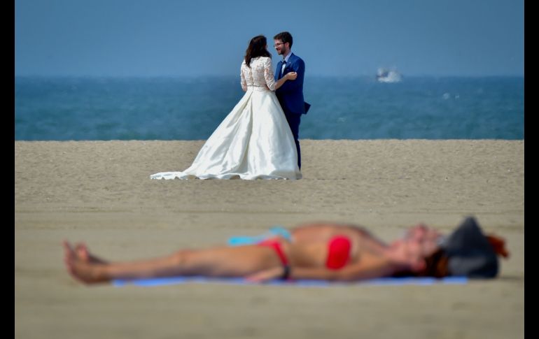 Una pareja posa para fotos en la playa de Deauville, Francia, donde se realiza el Festival de cine estadounidense de Deauville. AFP/L. Venance