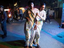 Un herido es ayudado por un voluntario, quien lo lleva a las afueras de un hospital. AP/R. Gul