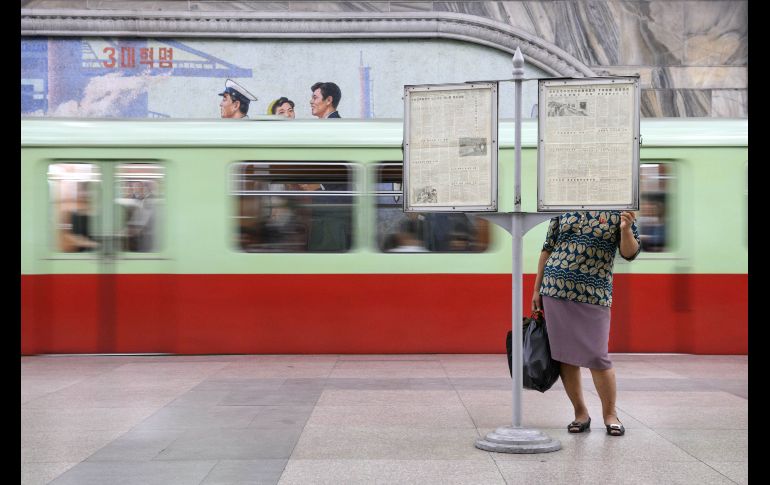 Una mujer lee un periódico en una plataforma de una estación de metro en Pyongyang, Corea del Norte. AFP/E. Jones