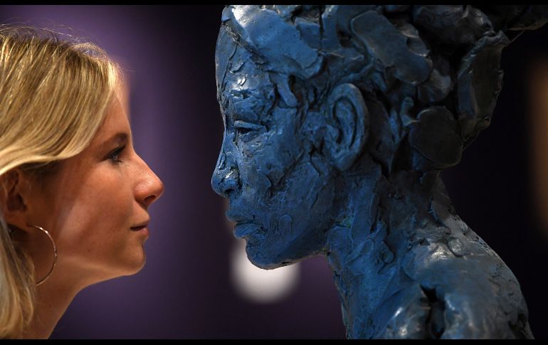 Una empleada observa la escultura de Lionel Smit ''Busto de una chica'', durante la presentación a los medios de la subasta de arte sudafricano en la casa de subastas de Bonham en Londres, Inglaterra. EFE/N. Hall