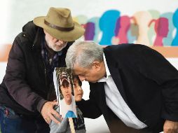 El escritor y activista Javier Sicilia y Andrés Manuel López Obrador saludan a un niño que muestra la fotografía de su padre desaparecido. EFE