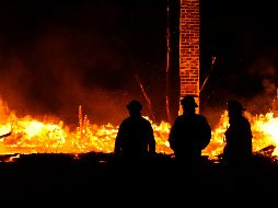 Bomberos trabajan a contrarreloj para intentar salvar la torre. AP/ARCHIVO