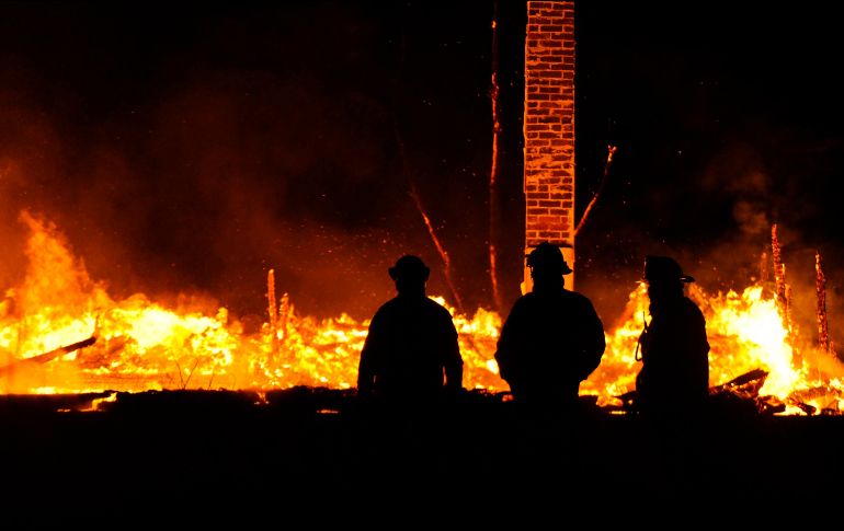 Bomberos trabajan a contrarreloj para intentar salvar la torre. AP/ARCHIVO