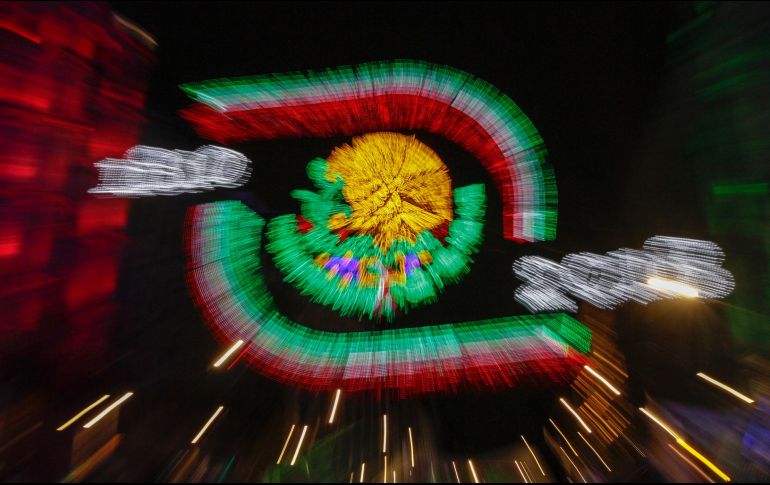 Los colores verde, blanco y rojo iluminaban las enormes paredes y balcones de Palacio Nacional, mientras en la plaza se veía a toda clase de personas. NTX/A. Rodríguez
