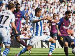 El defensa mexicano Héctor Moreno llega tarde en su intento por despojar del balón a Lionel Messi, en el partido de ayer entre la Real Sociedad y el Barcelona. AP