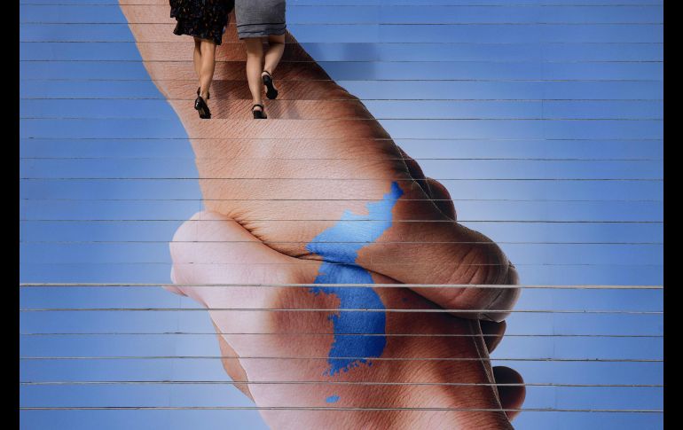 Una imagen de la península coreana cubre una escalera en Seúl, Corea del Norte. AFP/E. Jones