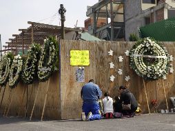 Familiares de algunos de los niños que perdieron la vida en el Colegio Rébsamen durante el terremoto de 2017 oran junto a un muro que resguarda las ruinas de esta escuela. EFE/S. Gutiérrez