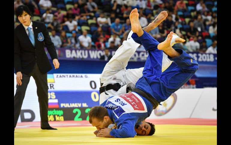 El ucranianao Georgii Zantanaraia (blanco) y el ruso Mikhail Puliaev pelean en el Campeonato Mundial de Judo, en la categoría de menos de 66 kilos, disputado en Bakú, Azerbaiyán. AFP/M. Antonov