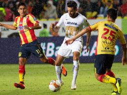 Los jugadores de Morelia Irven Ávila (i) y Roberto Meraz (d), pelean por el balón con Luis Quintana (c). EFE/L. Granados
