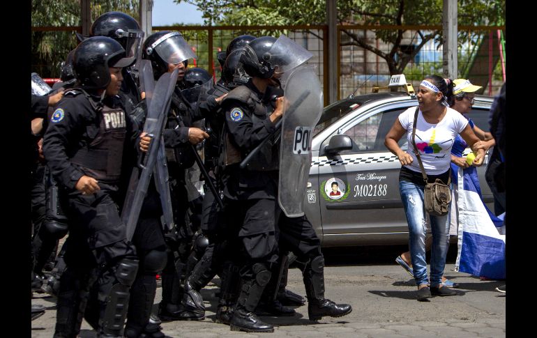 Miembros de la policía nacional bloquean la marcha opositora.