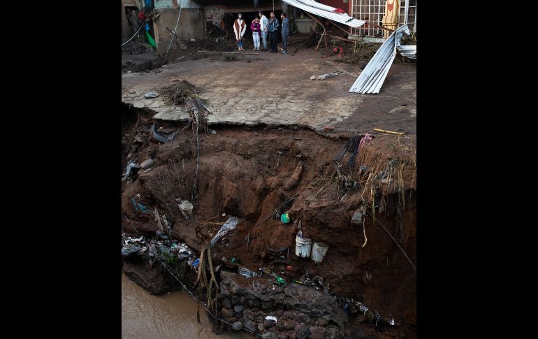 Habitantes observan los daños. Autoridades estatales informaron este lunes que suman cinco personas muertas y nueve más desaparecidas que fueron arrastradas por la corriente.