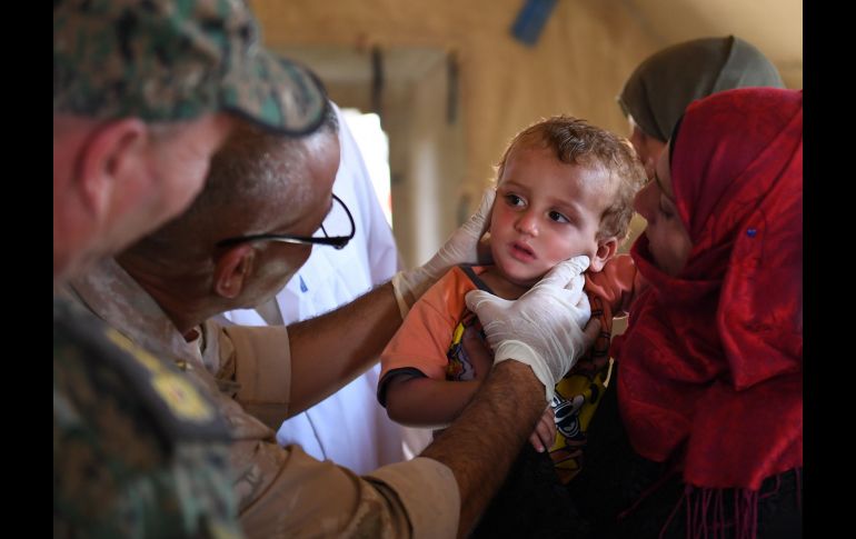 Un soldado ruso da atención médica a sirios en el cruce de Abu Duhu, en la provincia de Idleb, último bastión de los rebeldes sirios, luego de cruzar de la zona rebelde a la controlada por el régimen. AFP/G. Ourfalian