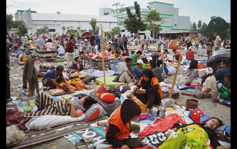 Equipos médicos improvisan una zona de atención afuera de un hospital en Palu. Rescatistas se apresuran a encontrar personas heridas tras la retirada del agua. AFP