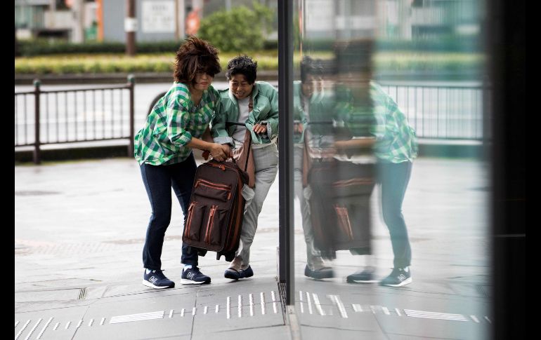 Peatones luchan contra el viento en Kagoshima, Japón, tras la entrada del tifón 