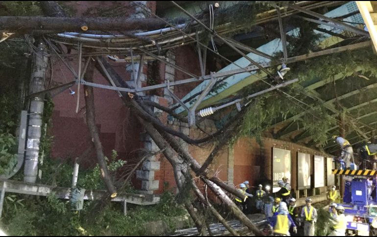 Personal de la compañía de trenes despeja las vías férreas, obstruidas por árboles caídos. Las lluvias ocasionaron el paro del tren bala y la cancelación de más de mil vuelos. EFE