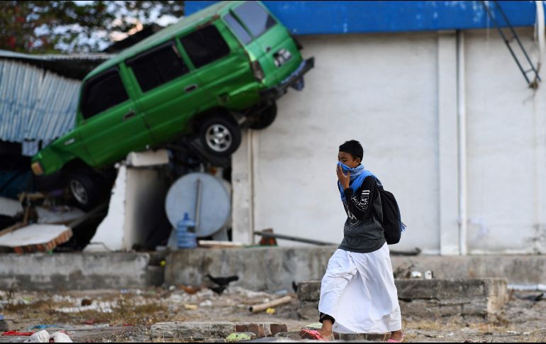 Un sobreviviente del desastre natural camina sobre el área dañanada en Palu, Indonesia. AFP / J. Samad