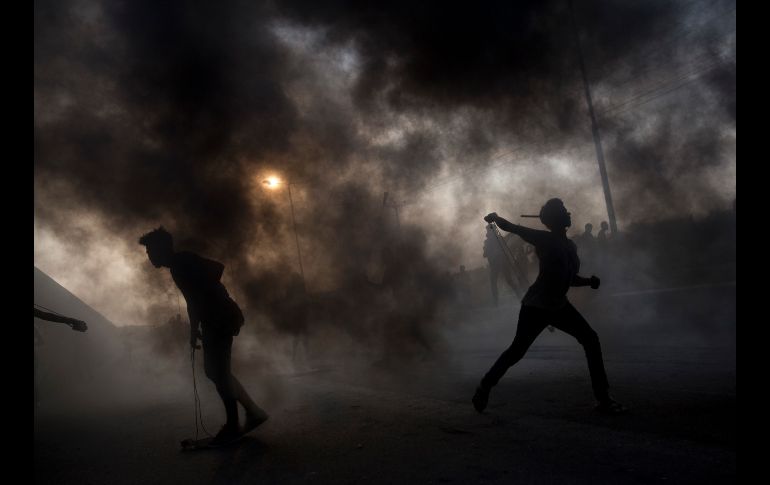 Palestinos lanzan piedras durante una protesta en la entrada del cruce fronterizo de Erez, en la Franja de Gaza. AP/K. Hamra