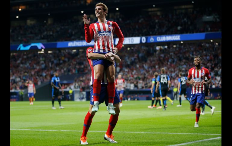 Antoine Griezmann (frente), del Atlético, festeja con Diego Godin, tras anotar un gol para su equipo ante Club Brugge, en partido de la Champions League en Madrid. AP/P. White
