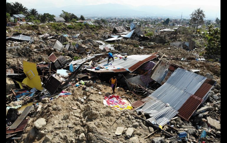 Sobrevivientes rescatan objetos de entre los escombros de una casa. AFP/J. Samad