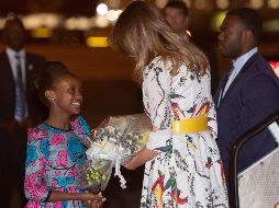 Una niña keniana le obsequia a Melania Trump un ramo de rosas a su llegada al aeropuerto. AFP/S. Loeb