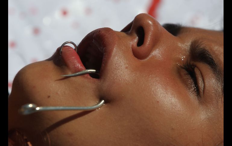 Activistas ambientales realizan una presentación en la que se colocaron anzuelos de pesca en la boca para representar el sufrimiento de los peces al ser atrapados, en el marco del Día Mundial de los Animales, en Cali, Colombia. EFE/E. Guzmán Jr.