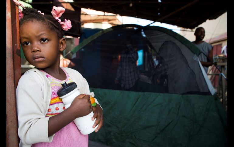 Una niña observa la calle mientras sus familiares organizan una tienda de campaña fuera de su vivienda en Port de Paix, Haití, luego del terremoto de 5.9 grados de magnitud que sacudió el sábado el norte del país y que ha causado al menos 12 muertos. EFE/O. Barría