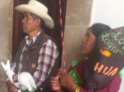 La mujer sostiene un globo metálico de estrella y un ramo de flores donde se lee: 