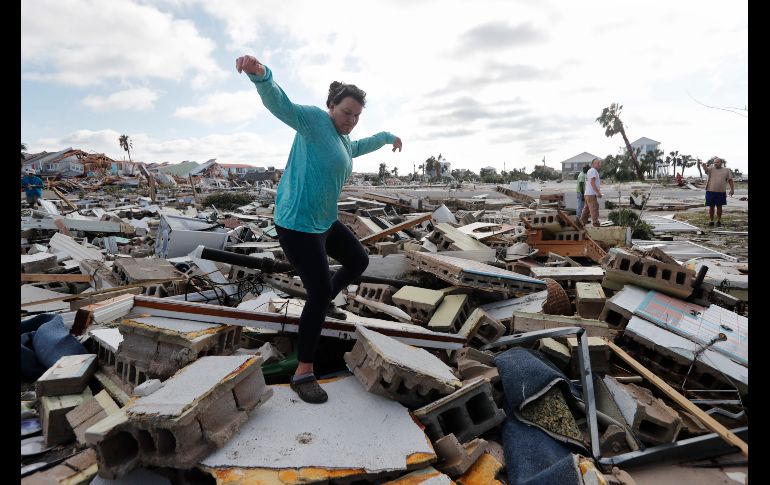 Mishelle McPherson camina entre los restos de la casa de su amiga, a quien busca pues supo que se quedó durante el huracán.