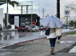 Una mujer camina hoy por una avenida de La Paz, en medio de encharcamientos. EFE/L. Roldán