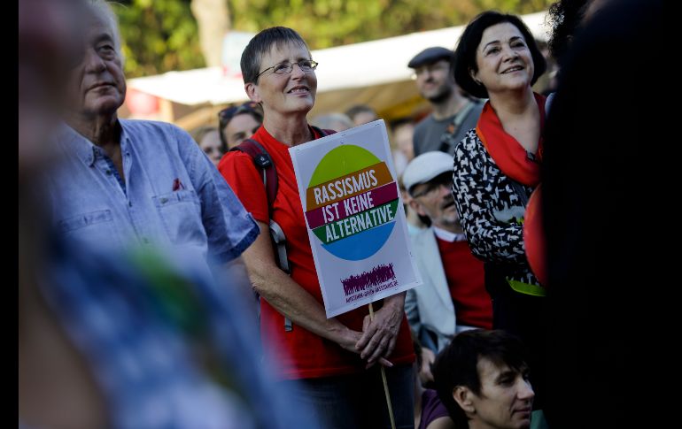 Una mujer sostiene un poster con el slogan 