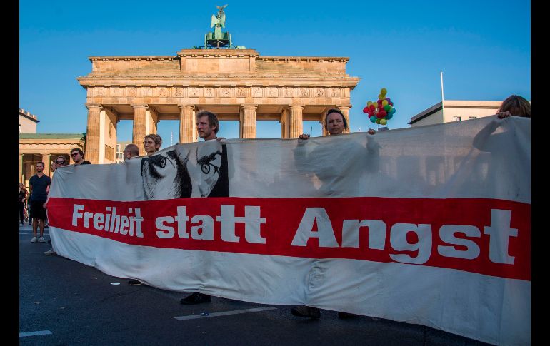 Manifestantes muestran un estandarte con la frase 