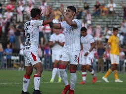 Pulido (D) celebra con Sandoval (I) tras anotar de penalti el primer gol de Chivas. TWITTER/@TigresOficial