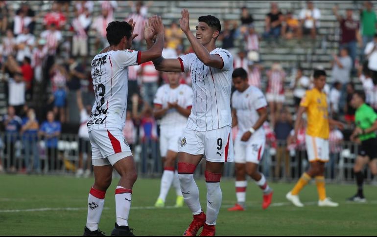 Pulido (D) celebra con Sandoval (I) tras anotar de penalti el primer gol de Chivas. TWITTER/@TigresOficial
