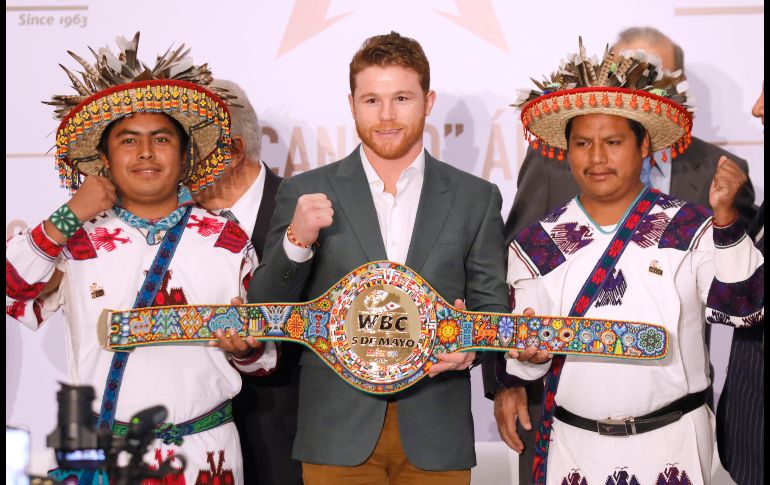 El mexicano Saúl 'Canelo' Álvarez, campeón de peso mediano del Consejo Mundial de Boxeo, posa en Ciudad de México con huicholes que realizaron el cinturón de arte que lo acredita como monarca del CMB. EFE/J. Núñez