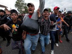 Migrantes hondureños cruzan una barricada de la policía guatemalteca en su camino a los Estados Unidos. AP / M. Castillo