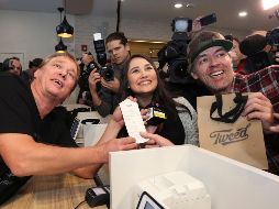 Bruce Linton, director general de Canopy Growth, posa con los primeros compradores legales de mariguana en su tienda en San Juan de Terranova. AP/P. Daly