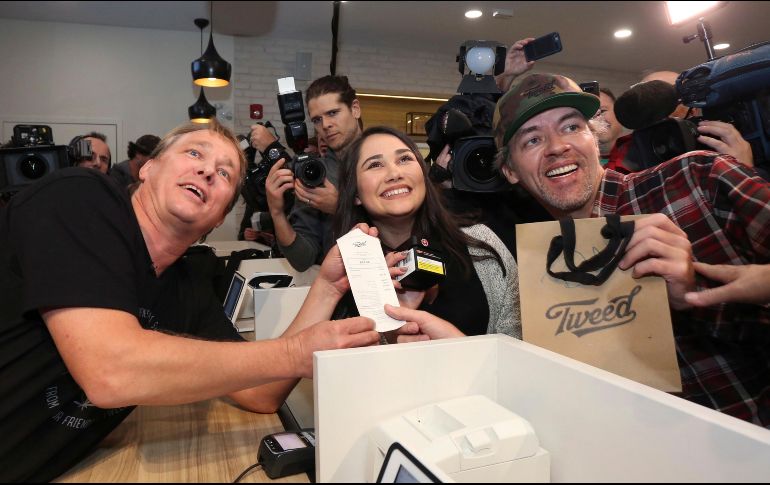 Bruce Linton, director general de Canopy Growth, posa con los primeros compradores legales de mariguana en su tienda en San Juan de Terranova. AP/P. Daly