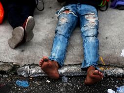 Hondureños descansan frente al albergue Casa del Migrante de Guatemala. Un primer grupo de la primera caravana ya llegó ayer a la frontera de Guatemala con México. EFE / E. Biba