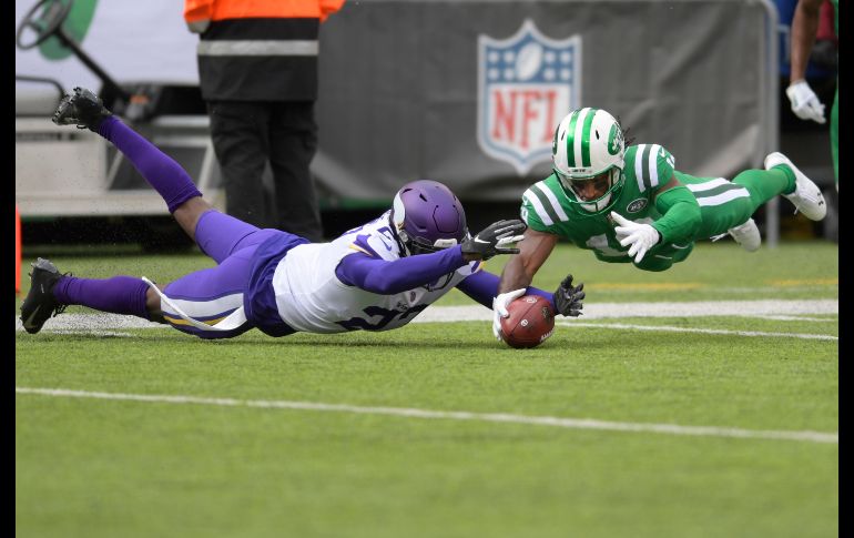 Andre Robert, de los Jets de Nueva York, y  Xavier Rhodes, de los Vikings de Minnesota, disputan un balón en la primera mitad del partido de la NFL en East Rutherford, Estados Unidos. AP/B. Kostroun