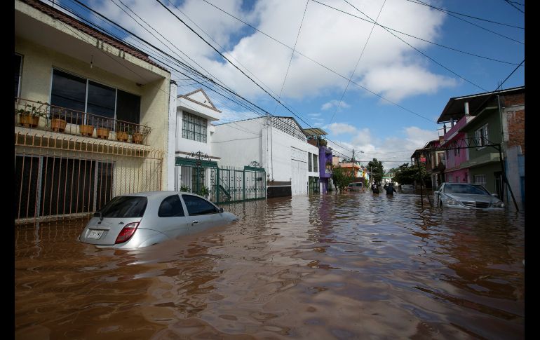 Vehículos quedaron en calle inundadas.
