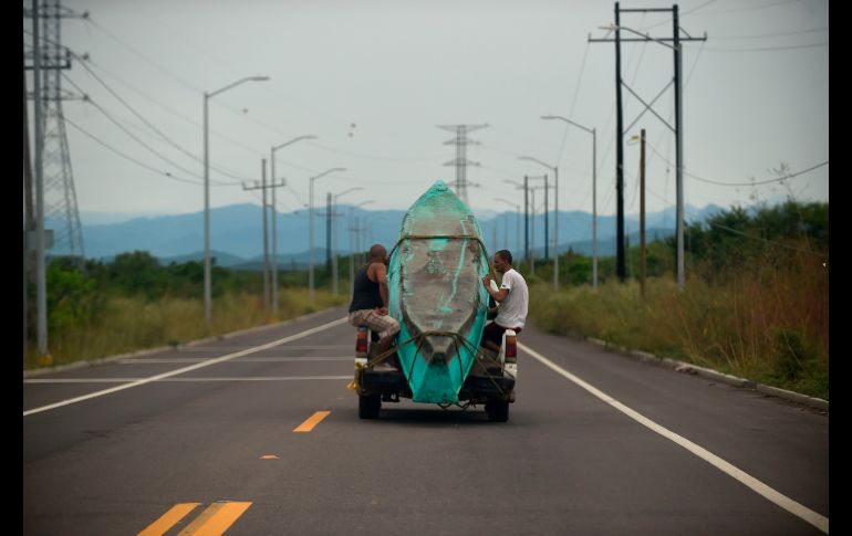 Hombres llevan un bote en Teacapan.