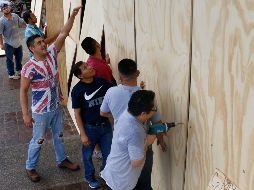 Habitantes protegen sus negocios ante la cercanía del huracán. EFE/F. Pérez