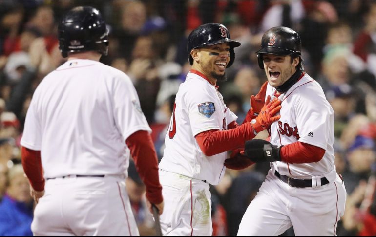 Mookie Betts y Andrew Benintendi celebran tras anotar las carreras que a la postre dieron la victoria a Boston, impulsadas por Julio Daniel Martínez. AFP/M. Meyer
